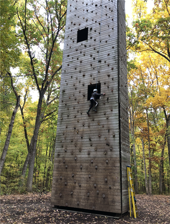 student climbing a wall